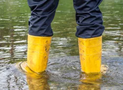 Person wearing boots in the floodwaters